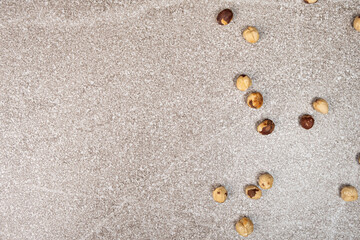 Roasted hazelnuts on a gray stone background top view, place for text