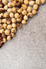 Roasted hazelnuts on a gray stone background top view, place for text