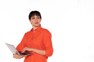 Young Woman in Orange Shirt Holding Laptop and Looking Away in Studio