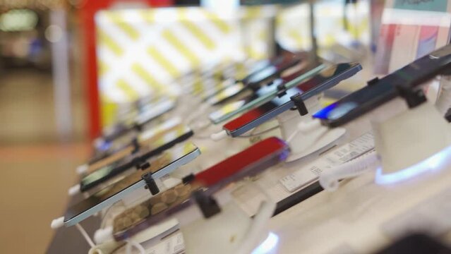 A lot of smartphone models on display at the exhibition stand of an electronics store