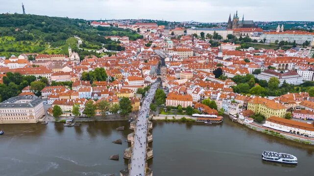 Aerial hyper lapse view of the old Lesser Town of Prague, Czech Republic, and Charles Bridge with people and boat traffic