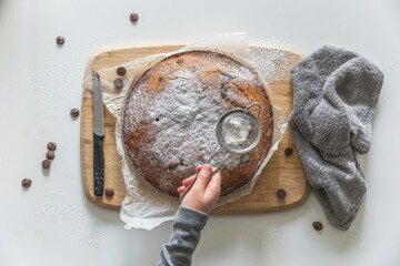 Home baking with young child, making super yum chocolate chip vanilla cake with confectioners sugar...
