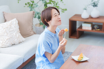 デザートのメロンを食べる女性