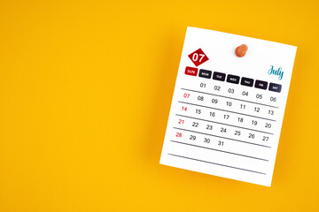 July 2024 calendar page with push pin on yellow background.