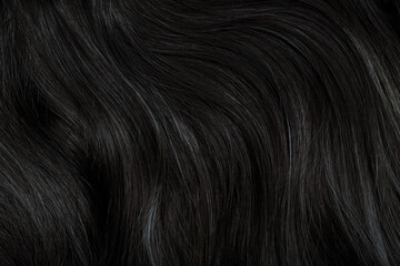 Brunette or black hair. Female long dark hair in black. Beautifully laid curls. Closeup texture in...