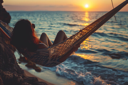 Woman in a hammock looking at the sunset on the beach. Relaxation Day on August 15 - Powered by Adobe