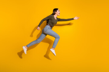 Fototapeta na wymiar Full body photo of attractive teen woman running hurry black friday dressed stylish khaki clothes isolated on yellow color background