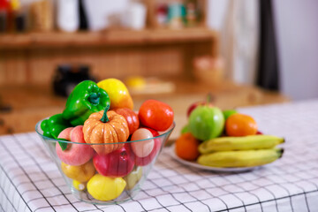 Plate of ripe fruits on a table in kitchen.