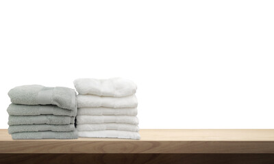 A pile of towels, neatly folded and placed on a wooden table.