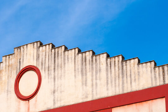 stepped gable wall detailed with a circular red window accent, offering a glimpse into classical decorative architectural style with modern element in Seville in Spain
