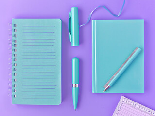 A collection of three turquoise stationery items, including a notebook, pen, and ruler, arranged in a triangular formation on a lavender backdrop with some copy space