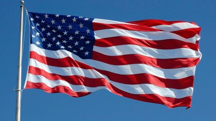Obraz premium Close-up view of the American flag waving against a clear blue sky