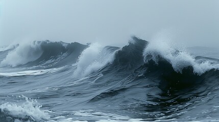Obraz premium Massive wave crests with foaming white caps against stormy sky. Turbulent waters in shades of steel blue and gray. Spray and mist create ethereal atmosphere.
