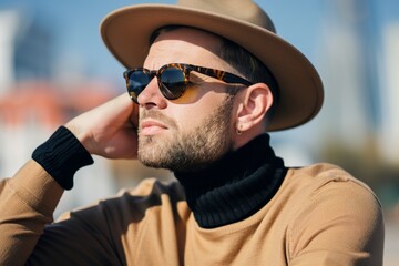 Obraz premium Stylish man in hat and sunglasses enjoying the sun