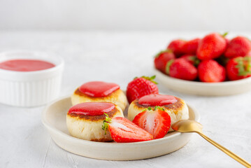 Vegan cheesecakes, syrniki, cheese pancakes with strawberries, jam, cashew, tofu in a plate. Sugar, lactose and gluten free.