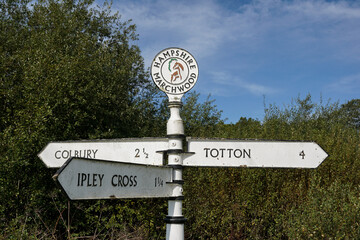 vintage signpost in Marchwood, England with travel directions to Totton and Colbury. Old fashioned roadside fingerpost