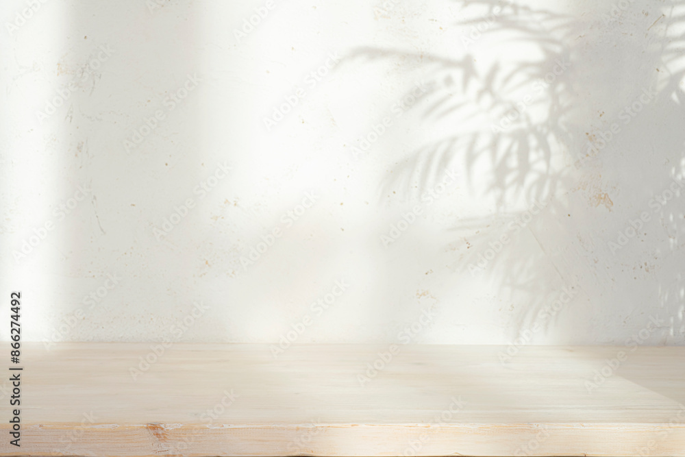 Wall mural bleached empty wooden table top with leaves shadow on abstract stucco wall texture background