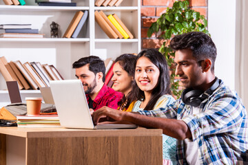 Indian asian four college or university students using laptop together