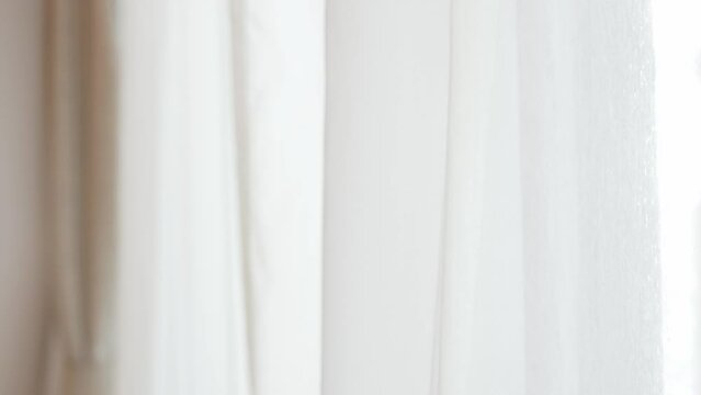 out of focusing blurred view of transparent white curtain at big glasses window, door while wind blowing the curtain in morning summer holiday time