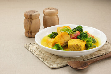 Salmon Kuah Kuning, fish soup with broccoli and tomatoes. Indonesian food
