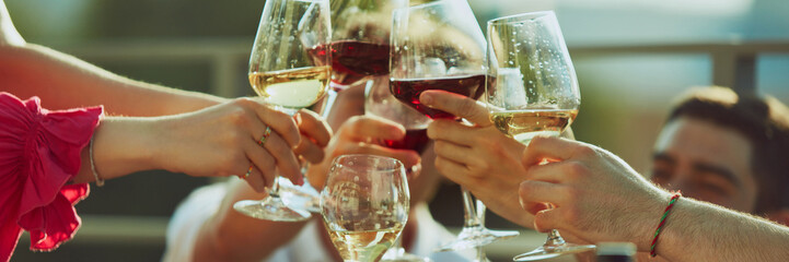Banner. Young adults enjoy sunny celebration, raising their drinks high in toast to friendship and fun. Concept of party, Friday mood, celebration, summer holidays, relax.