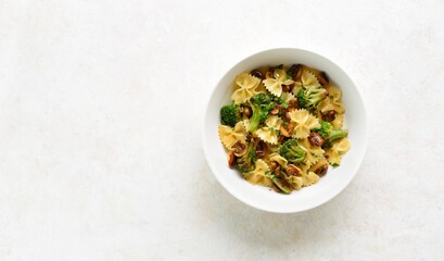 Farfalle pasta with roasted broccoli and mushrooms in bowl