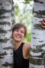 Beautiful woman with an emotional expression on the background of birches, embodying harmony with...