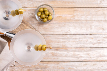Vodka martini cocktail with vodka and vermouth and green olives on wooden table