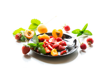 fresh fruit salad of ripe strawberries and apricots, isolated on a white background