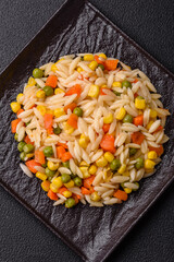 Delicious boiled rice with vegetables corn, carrots, peas with salt