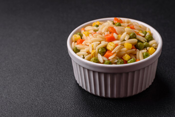 Delicious boiled rice with vegetables corn, carrots, peas with salt