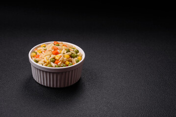 Delicious boiled rice with vegetables corn, carrots, peas with salt