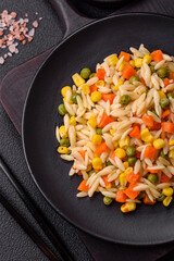 Delicious boiled rice with vegetables corn, carrots, peas with salt