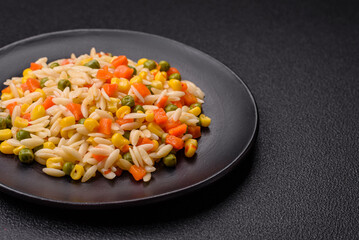 Delicious boiled rice with vegetables corn, carrots, peas with salt