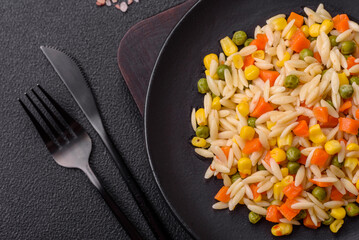Delicious boiled rice with vegetables corn, carrots, peas with salt