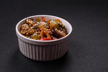 Spicy Asian dish with sliced meat fillet, hot pepper, carrots and sesame seeds