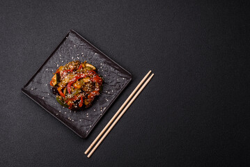 Spicy Asian dish with sliced meat fillet, hot pepper, carrots and sesame seeds