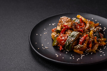 Spicy Asian dish with sliced meat fillet, hot pepper, carrots and sesame seeds