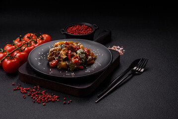 Spicy Asian dish with sliced meat fillet, hot pepper, carrots and sesame seeds