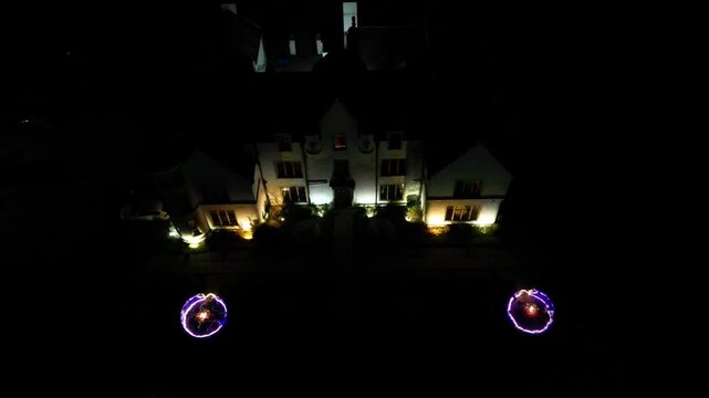 Downwards drone top down aerial luxury hotel restaurant dinner bubbles igloos dark night facade historical