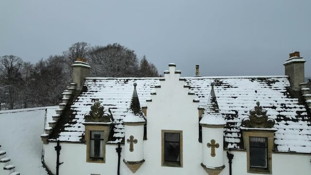 Scottish Castle estate luxury house property countryhouse winter cold snow covered aerial drone forward shot tower cross reveal area overflying roof flypast