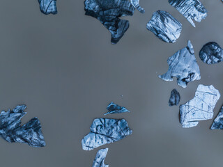 Stunning aerial view of a glacial lagoon in Iceland, featuring numerous blue and white icebergs of...