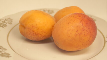 ripe apricots on a white plate