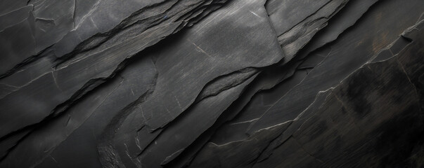 Closeup background of dark black slate with visible details and textures, capturing intricate patterns in the rock surface.