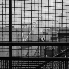 Big satellite dish photographed trough a wire net.