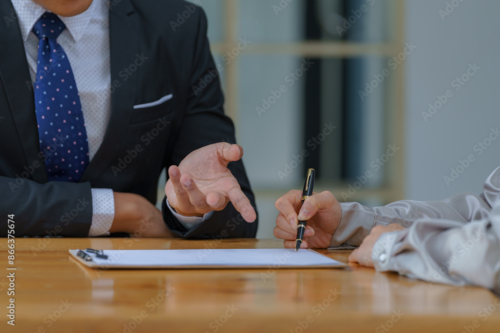Aufkleber two people are sitting at a table with a piece of paper in front of them. one person points at the p