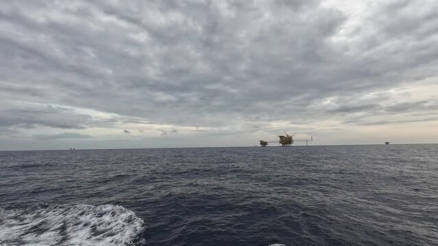 man walking on the beaCentral processing platform (cpp) in the middle of the ocean during sunset - upstream industry
ch