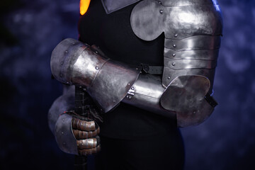Naklejka premium Close-up of armor, knight's steel hands on an abstract background.