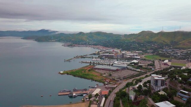 Port Moresby Harbour Papua New Guinea aerial drone morning cloudy foggy sunrise PNG Crown Hotel Plaza Hilton Ela Beach Walter Bay car traffic Coral Sea coastline capital city mountains forward motion