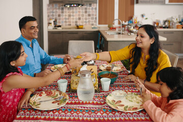 Indian family of four having dinner together at home